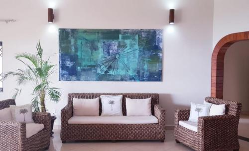 a living room with two chairs and a painting on the wall at Calm Sorento in Glacis