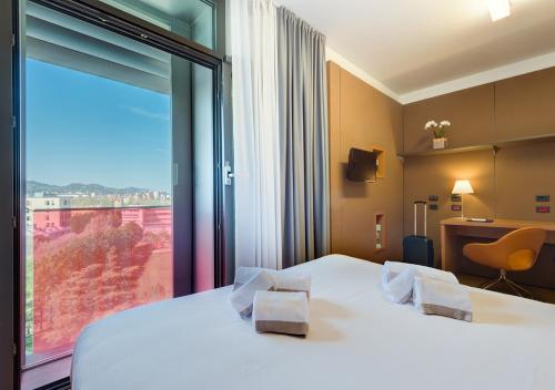 a hotel room with a bed and a large window at Camplus Bononia Casa per Ferie in Bologna
