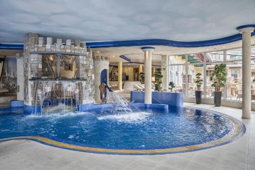 a large pool in a building with a fountain at Cocoon - Alpine Boutique Lodge in Maurach