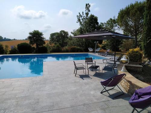 a swimming pool with chairs and an umbrella at Bastide De Luzert in Labastide-de-Lévis