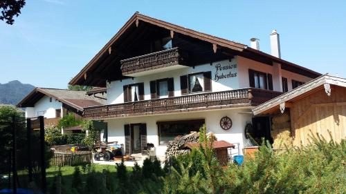 a large house with a balcony on top of it at Wellness Pension Hubertus in Marquartstein