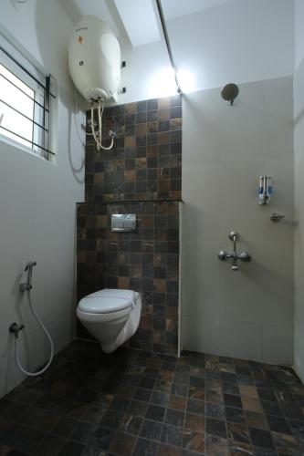 a bathroom with a toilet and a shower at The Hill Side in Ooty