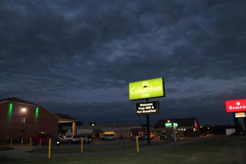 a yellow caulking inn sign in a parking lot at Columbus Inn in Columbus
