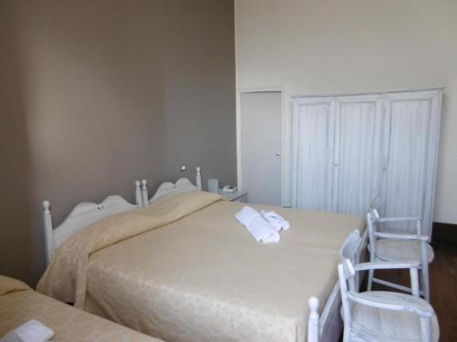 a bedroom with two beds and two chairs at Hotel Villa Maria in Sanremo