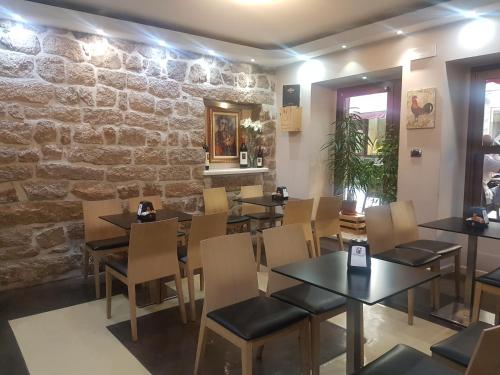 a restaurant with tables and chairs and a stone wall at Il Gallo di Gallura in Tempio Pausania