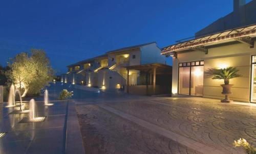an empty courtyard of a building at night at Verde Al Mare Boutique Hotel in Kalogria
