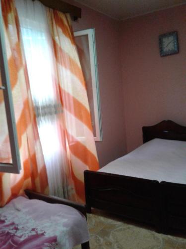 a bedroom with two beds and an orange curtain at Guest house maka in Gonio