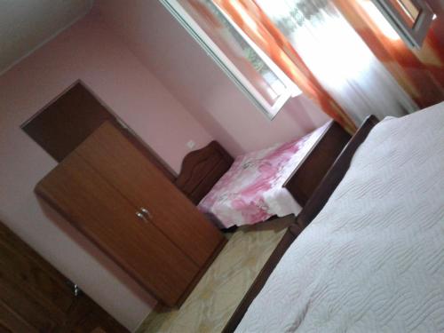 a bedroom with a bed and a dresser with a dresservelt at Guest house maka in Gonio