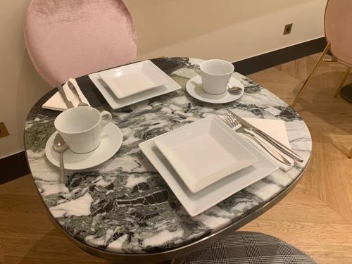 a table with two cups and saucers on it at Hôtel Léna in Paris