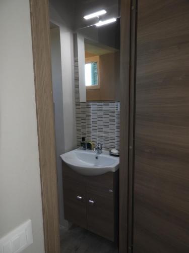 ein Badezimmer mit Waschbecken und Spiegel in der Unterkunft HOME ORTE in Orte