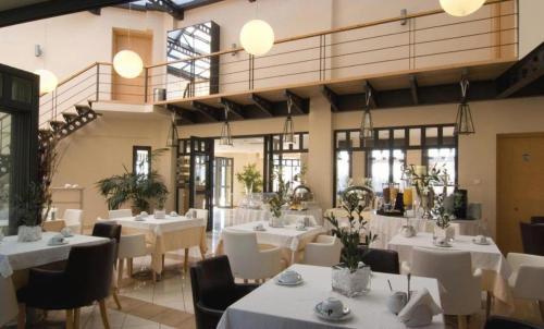 a dining room with white tables and chairs at Verde Al Mare Boutique Hotel in Kalogria
