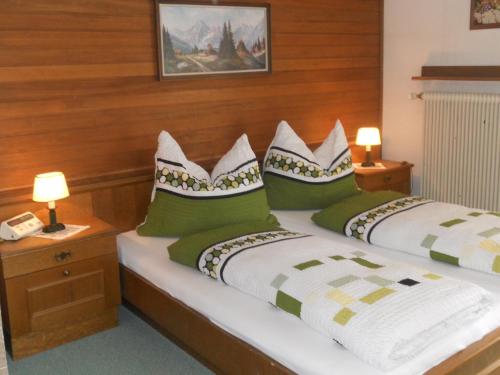 a bedroom with two beds with green and white pillows at Haus zur Linde in Wagrain