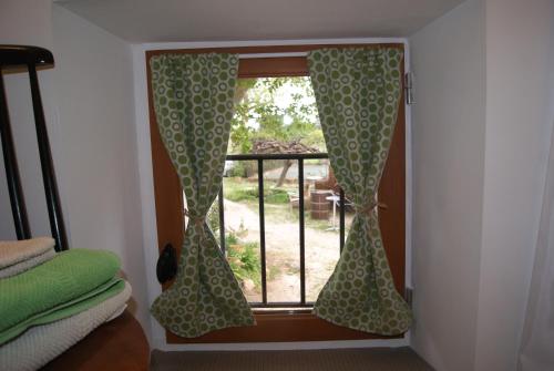 a window with curtains in front of a balcony at LE BOURGUET in Solliès-Pont