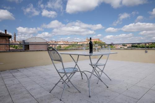 a table with a bottle of wine sitting on a roof at Porta Pispini Residence in Siena