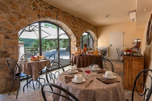 a dining room with tables and chairs and a stone wall at Borgo di Villa Cellaia Resort & SPA in Dicomano