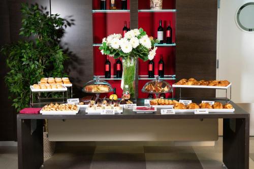 a table with various pastries and bottles of wine at Hotel Nazionale in Matera