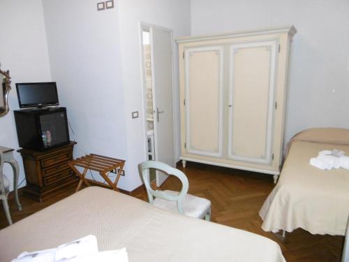 a room with two beds and a tv in it at Hotel Villa Maria in Sanremo