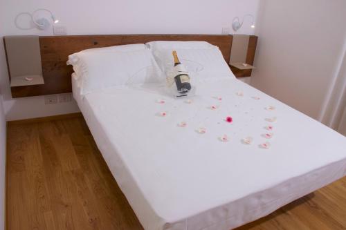 a white bed with a bottle of wine on it at Chiaroscuro in Belforte del Chienti