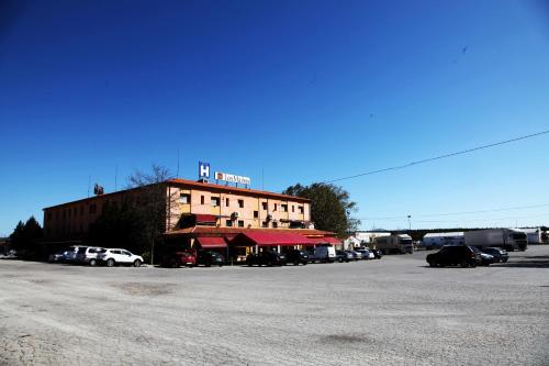 a building with cars parked in a parking lot at Hostal Los Maños in Albentosa
