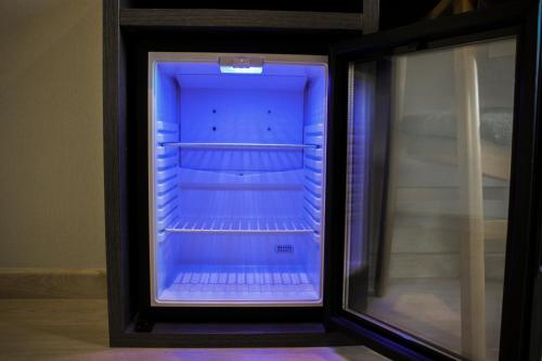 an empty refrigerator with blue light inside of it at Hotel Nacional in La Jonquera