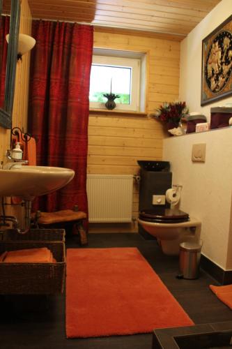 a bathroom with a sink and a toilet and a window at FeWo - Wohlfühlambiente & Gartenparadies in Modautal