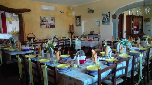 a dining room with a long table with plates and bowls at Il Cardoncello in Sindia