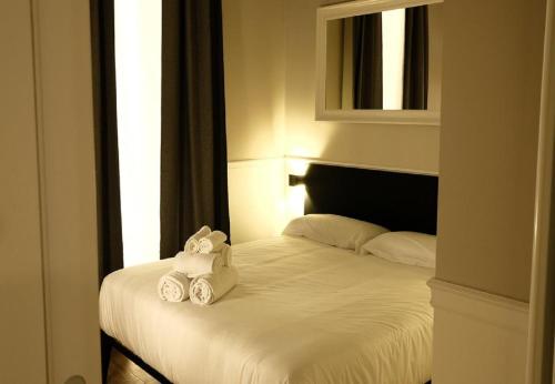 a bedroom with a bed with two towels on it at KUKKA ROOMS in Naples