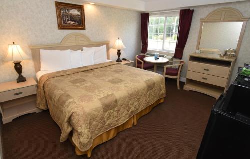 a hotel room with a bed and a mirror at Country View Inn & Suites Atlantic City in Galloway