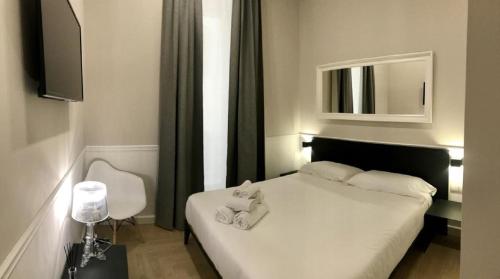 a bedroom with a bed with two towels on it at KUKKA ROOMS in Naples