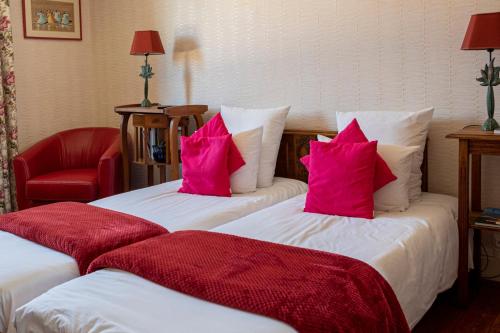 two beds in a hotel room with pink pillows at l'abri du viaduc in Saint-Satur
