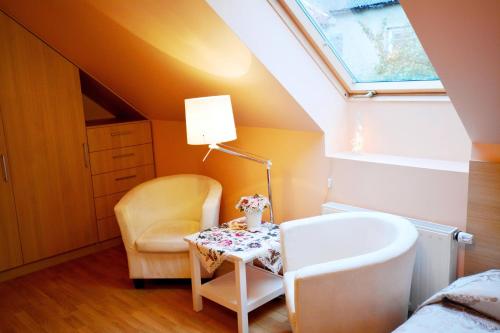 a bathroom with a chair and a table and a lamp at Vila Liepa in Birštonas