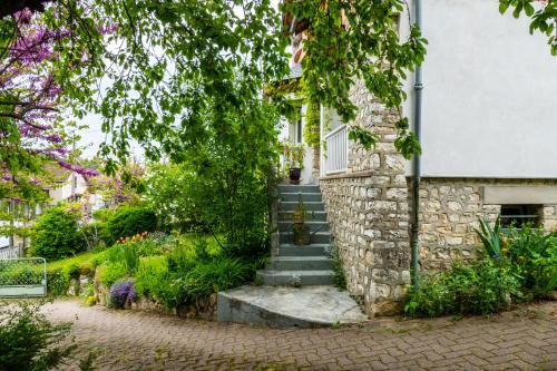 a stone house with stairs and flowers in front of it at l'abri du viaduc in Saint-Satur