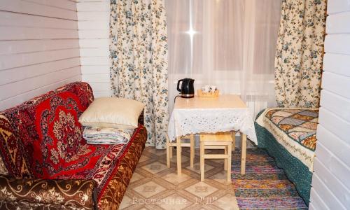 ジヴェエヴォにあるGuest House on Vostochnaya d 1Dの小さなお部屋で、テーブルとソファが備わります。