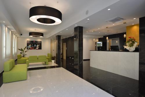 a lobby with a green chair and a reception desk at Hotel Ducale in Rimini