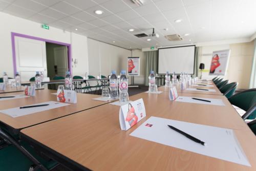a large conference room with a long table with chairs at ibis Issy les Moulineaux "Val de Seine" in Issy-les-Moulineaux