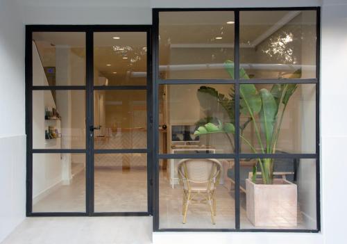 a glass door with a vase with a plant in it at YOU & CO. Saler Beach Boutique in Valencia