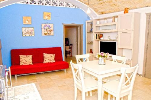 a living room with a red couch and a table at Casetta San Domenico apartment in Monopoli