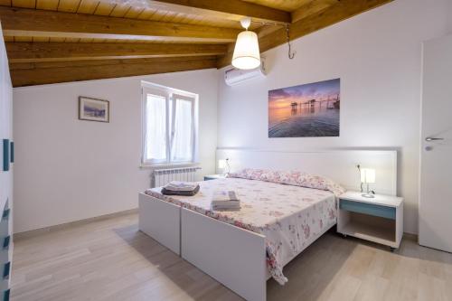 a white bedroom with a bed and a window at Colibri B&B in Lanciano