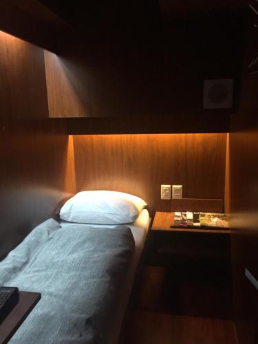 um quarto com uma cama e uma mesa de cabeceira com uma cama sidx sidx sidx sidx em Onkel Inn Airport Sleepbox em La Paz