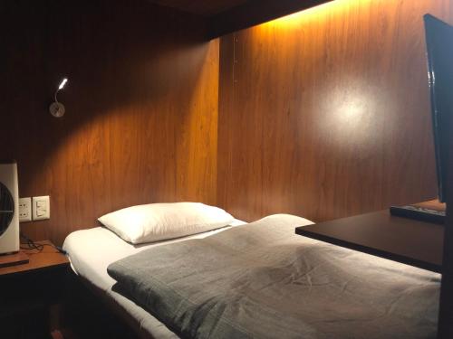 um quarto com uma cama e uma parede de madeira em Onkel Inn Airport Sleepbox em La Paz