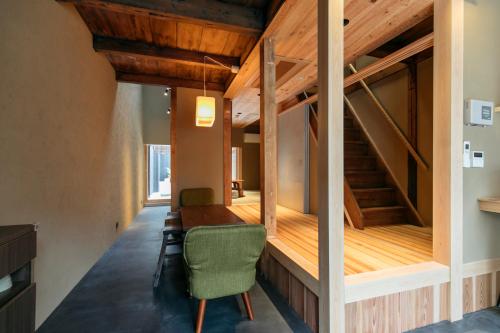 Pokój z drewnianym stołem i zielonym krzesłem w obiekcie MACHIYADO 京都南禅寺道 w mieście Kioto
