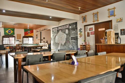 uma sala de jantar com mesas e cadeiras de madeira em Hostel Chocolatchê em Gramado