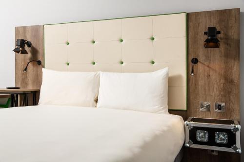 a bedroom with a large bed with white pillows at ibis Styles London Ealing in London