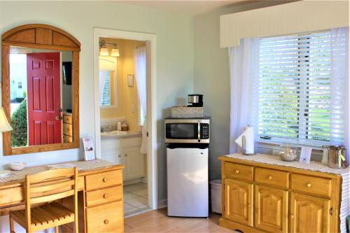 eine Küche mit einem weißen Kühlschrank und einer roten Tür in der Unterkunft Red Horse Inn in Falmouth
