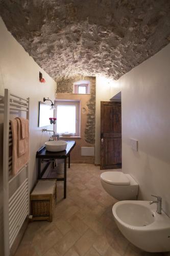 a bathroom with a sink and two toilets in a room at B&B dell'Osteria in SantʼAnatolia di Narco