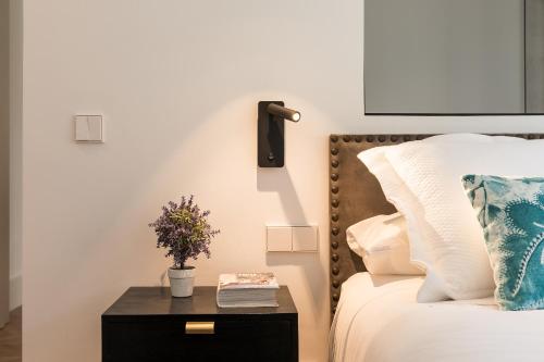 a bedroom with a bed and a table with a plant on it at Feelathome Waldorf Suites Apartments in Madrid