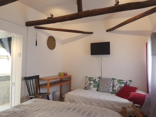 sypialnia z łóżkiem i telewizorem na ścianie w obiekcie Nether Oslands w mieście Lower Swanwick