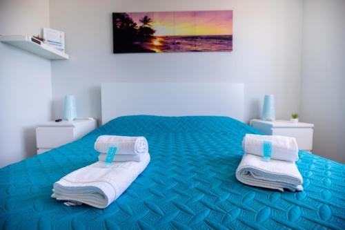 エリセイラにあるEriceira Atlanticのベッドルーム1室(ブルーベッド1台、タオル付)