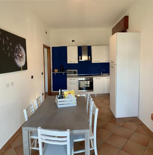 a kitchen with a table and chairs and a refrigerator at Villa Lori Apartments Garden and Beach in Peschiera del Garda