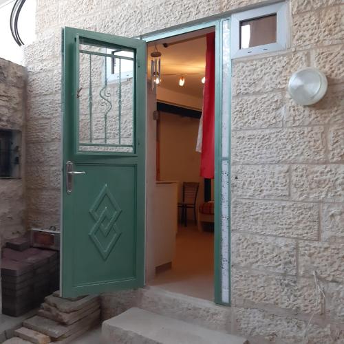 a green door in a brick wall with a doorway at Wild Rose in Jerusalem